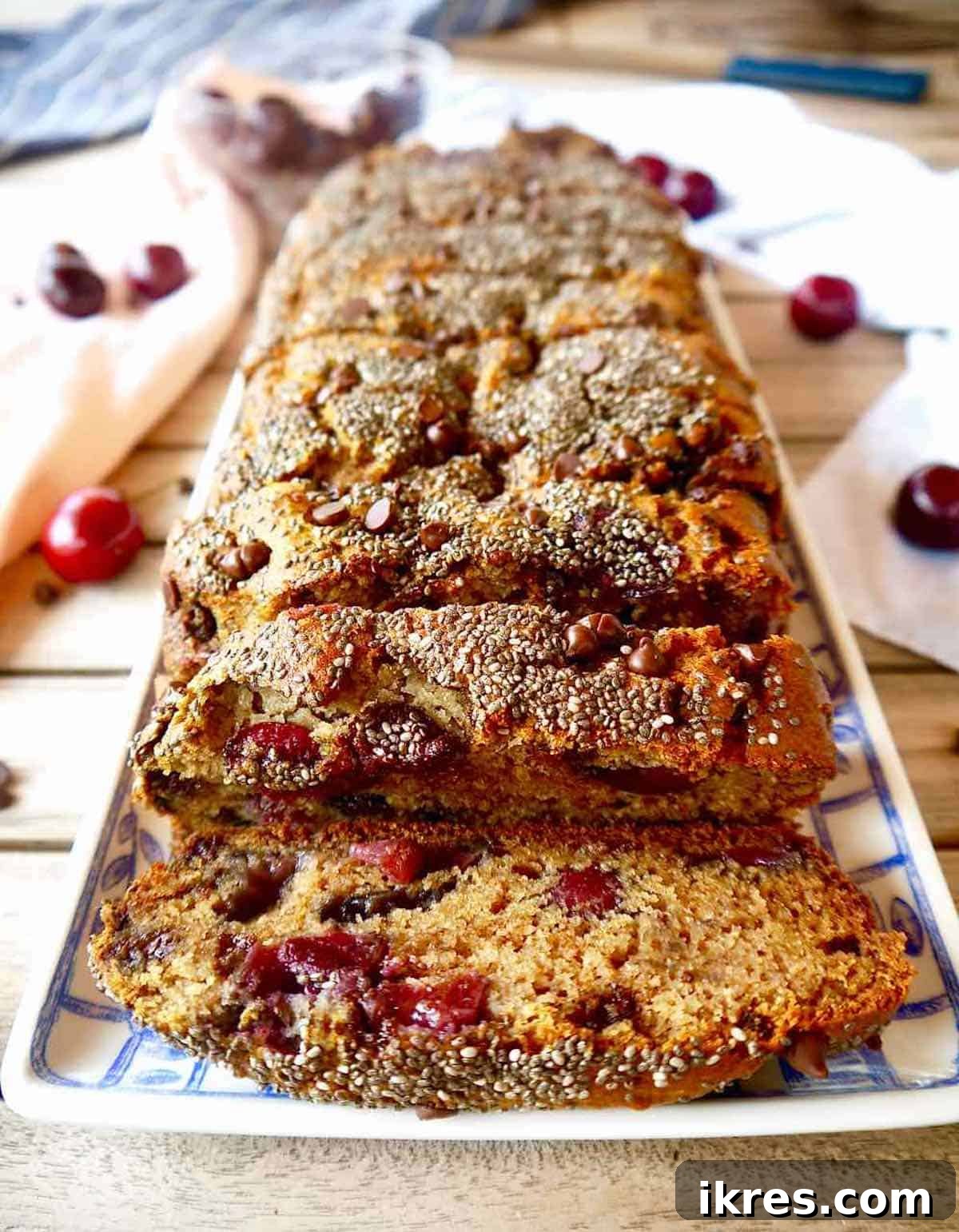 Pure Paleo Cherry Banana Loaf 5 A perfectly baked loaf of Paleo cherry banana bread, sliced to reveal the moist interior with cherries and chocolate chips.