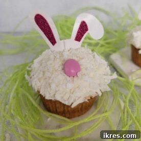 Easy Bunny Cupcakes, decorated with fluffy frosting, marshmallow bunny tails, and candy feet, perfect for Easter or Spring Parties, taking minutes to prepare and looking super cute.