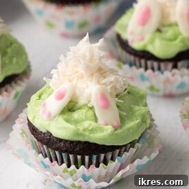 Bunny Butt Cupcakes featuring a moist chocolate cupcake with a marshmallow and coconut flake bunny playfully diving into buttercream grass, making it the perfect Easter treat.