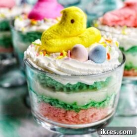 Mini Easter Trifles, a delicious and easy layered dessert crafted with cake, pudding, shredded coconut, and whipped cream, then topped with an array of favorite Easter candies.