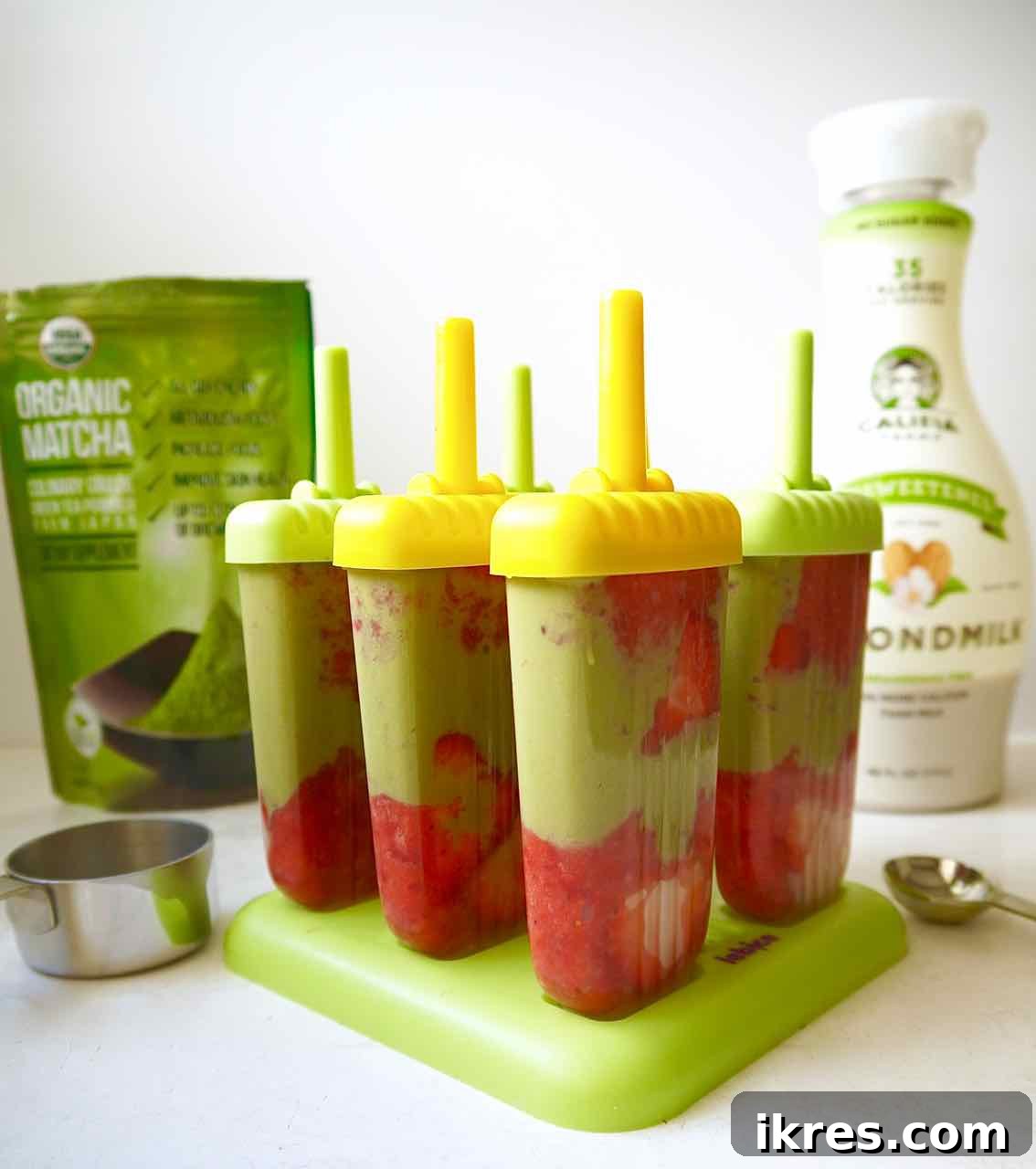 Strawberry Matcha Fusion Pops 5 Popsicle molds filled with alternating layers of strawberry puree and matcha latte, prior to freezing.