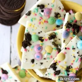 A delightful Easter Oreo bark, featuring a base of vanilla candy coating, studded with pastel Easter M&M’s, crushed Oreos, and festive sprinkles, creating a quick and easy holiday treat.