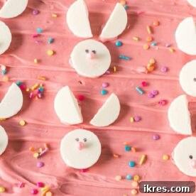 An easy Easter Bunny Bark featuring pastel pink chocolate swirled with white, topped with sprinkles and festive candies, shaped into an adorable bunny outline for a simple no-bake treat.