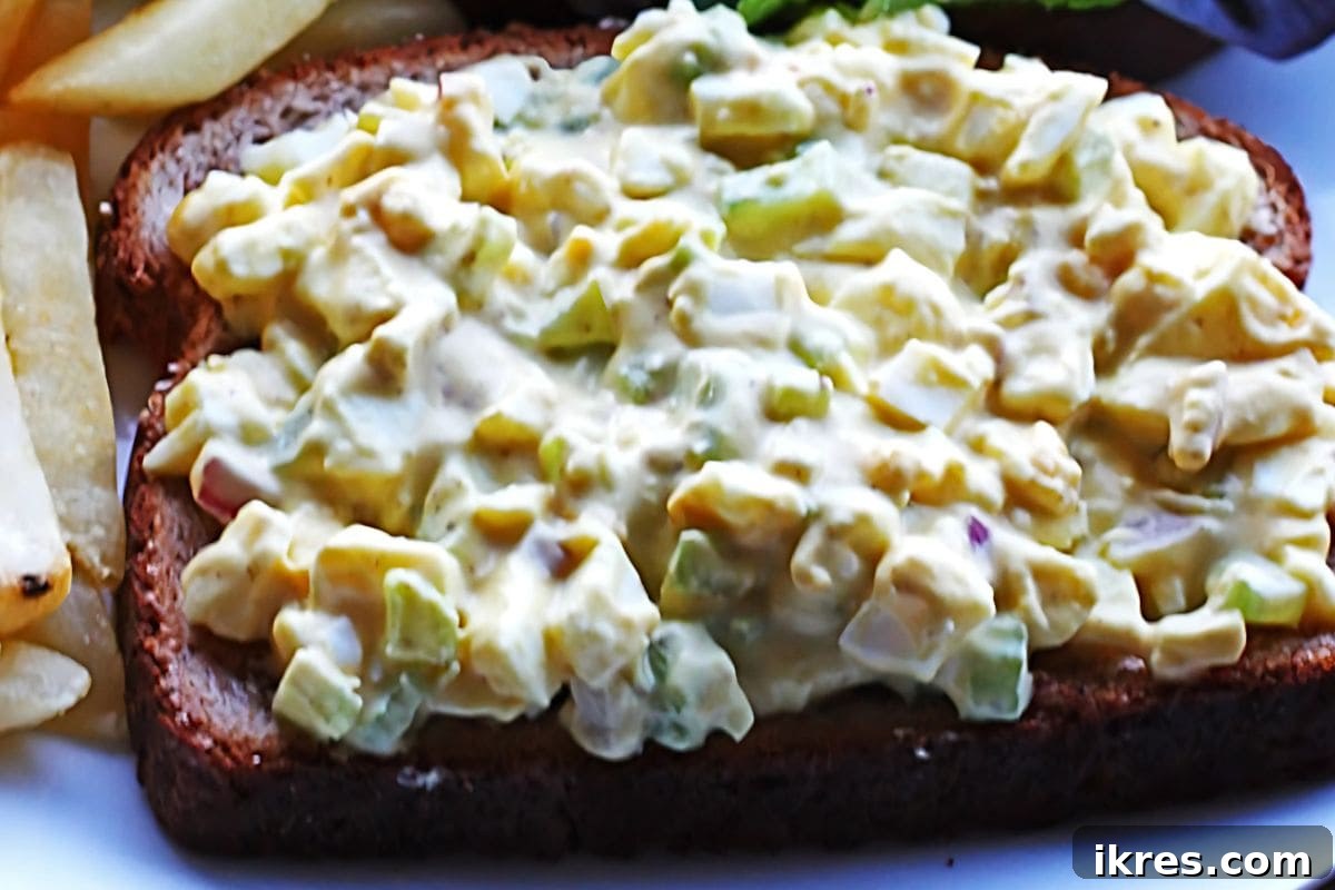 Creamy and delicious Easy Egg Salad with celery and onions, served as a sandwich.