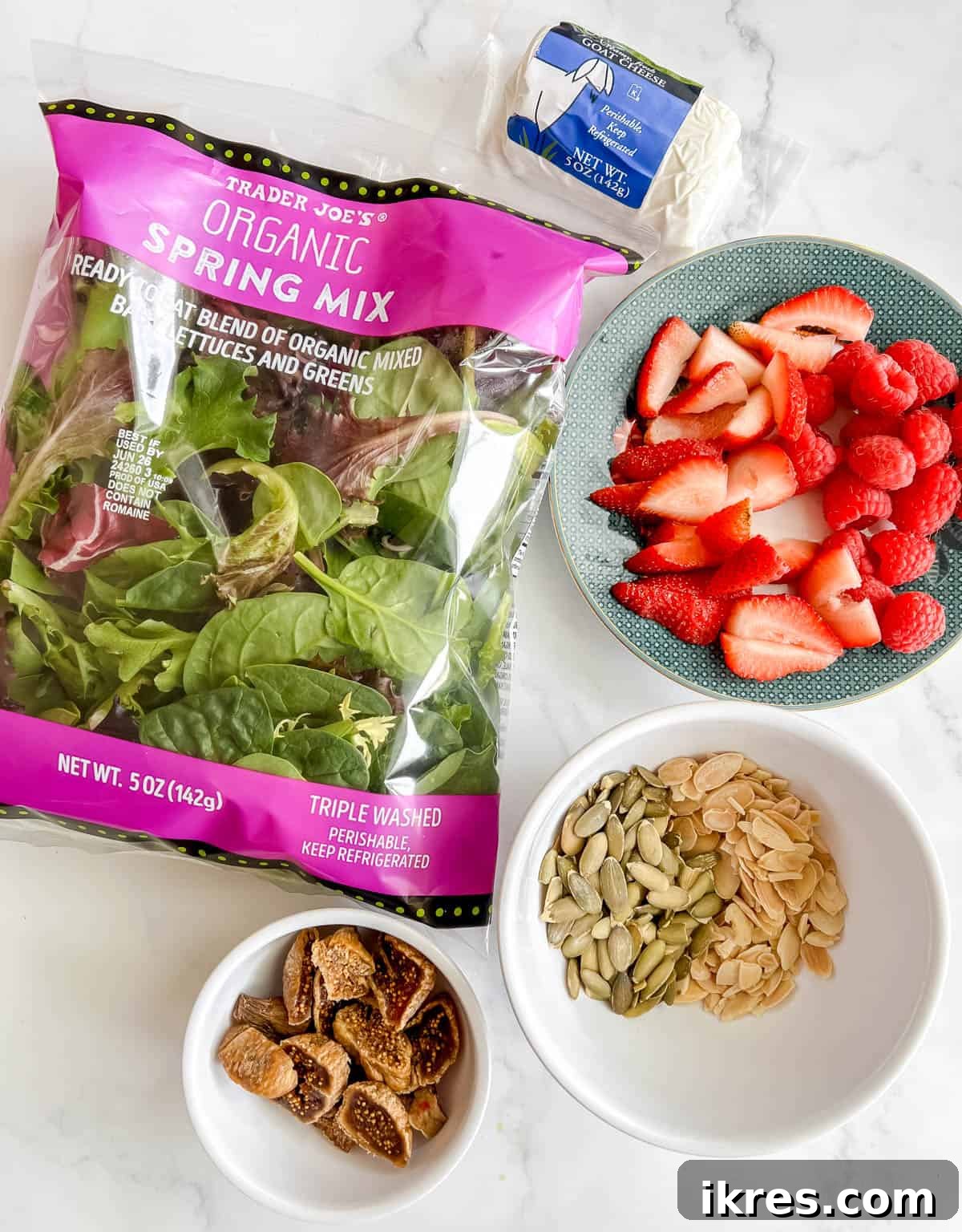 Vibrant Berry and Fig Salad with Creamy Chevre and Vanilla Vinaigrette 3 A vibrant selection of fresh produce including mixed greens, strawberries, raspberries, almonds, pumpkin seeds, and dried figs, laid out for a Berry and Fig Salad.