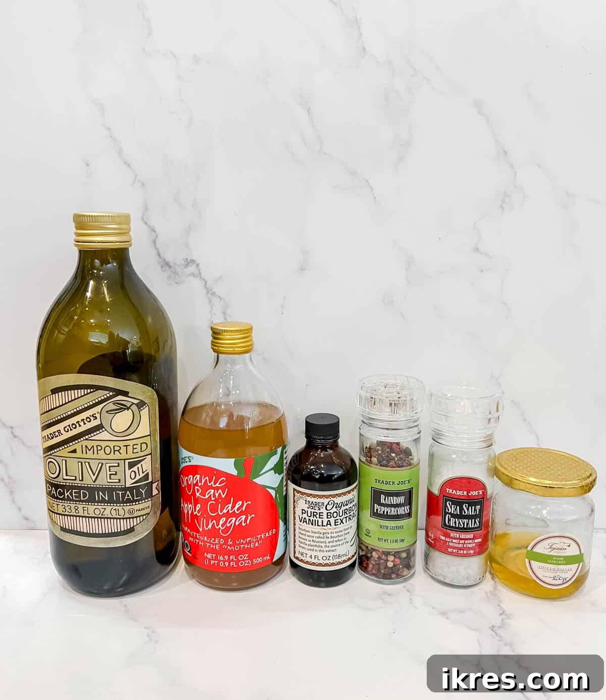 Vibrant Berry and Fig Salad with Creamy Chevre and Vanilla Vinaigrette 4 Key ingredients for the homemade vanilla vinaigrette, featuring olive oil, apple cider vinegar, a bottle of vanilla extract, and golden honey.