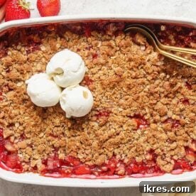 A warm Old-Fashioned Strawberry Rhubarb Crisp topped with a generous oat crumble.