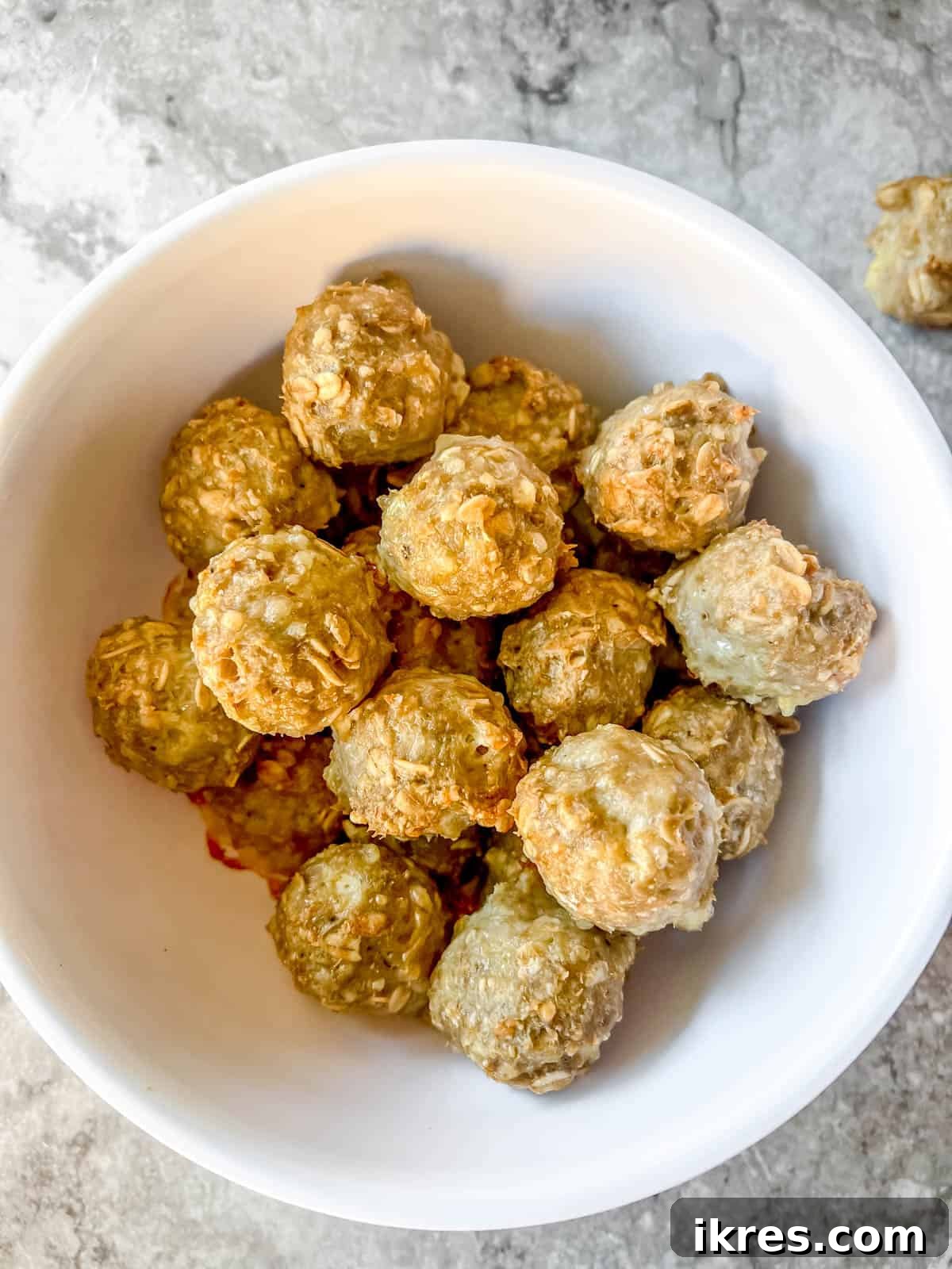Close-up of baked gluten-free turkey meatballs made with oats, glistening in a bowl.