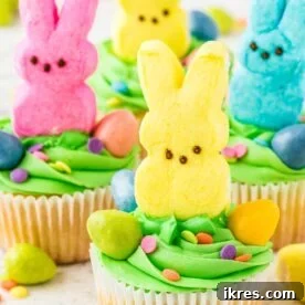 A tray of decorated PEEPS Cupcakes with fluffy frosting and colorful marshmallow Peeps.