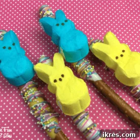A selection of Easter Peeps Pretzel Rods, adorned with colorful sprinkles and topped with marshmallow Peeps.