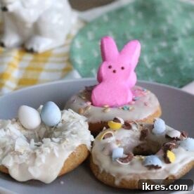 A collection of beautifully decorated Easter donuts, topped with colorful Peeps and sprinkles.