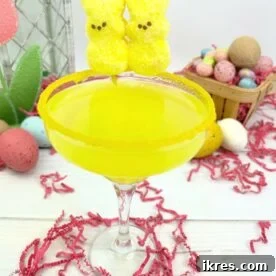 A pink Easter Peeps Martini, garnished with a marshmallow bunny Peep and rimmed with sprinkles.