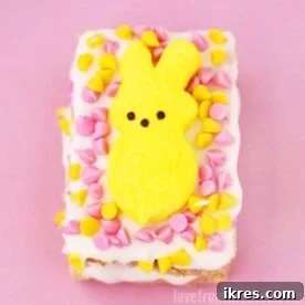 Close-up of a square Peeps Stuffed Crispy Treat for Easter, showing a colorful marshmallow Peep inside a golden Rice Krispie square.