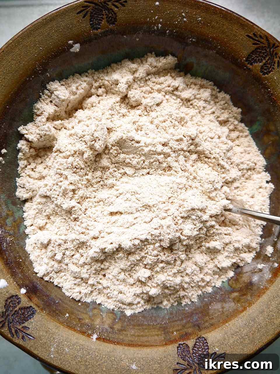 Wholesome Grain-Free Apple Cake with Almond Flour 4 Dry ingredients for Paleo apple cake, including almond flour, coconut flour, tapioca flour, baking soda, salt, and cinnamon, mixed in a bowl.