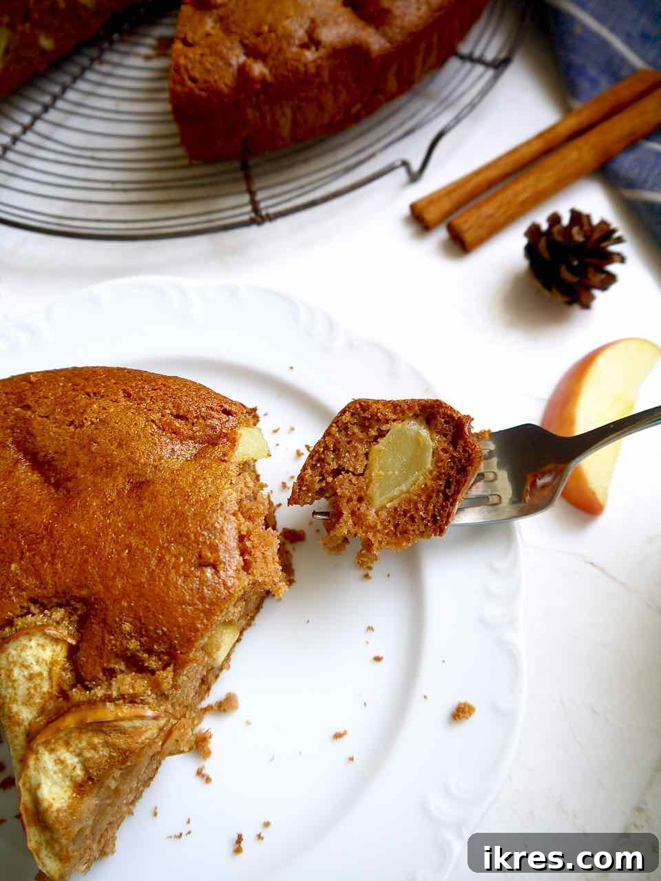 Wholesome Grain-Free Apple Cake with Almond Flour 8 A close-up of a bite of healthy almond flour apple cake on a plate, showing the soft crumb and apple pieces.