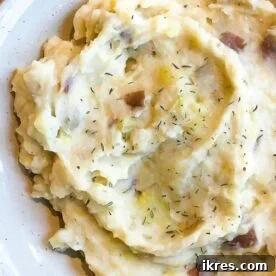 Instant Pot garlic mashed potatoes, served with herbs.