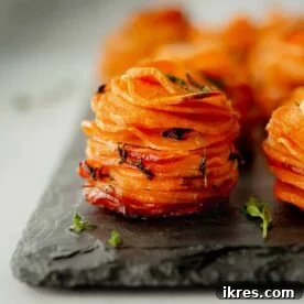 Individually-sized sweet potato stacks baked with butter and thyme in muffin tins.
