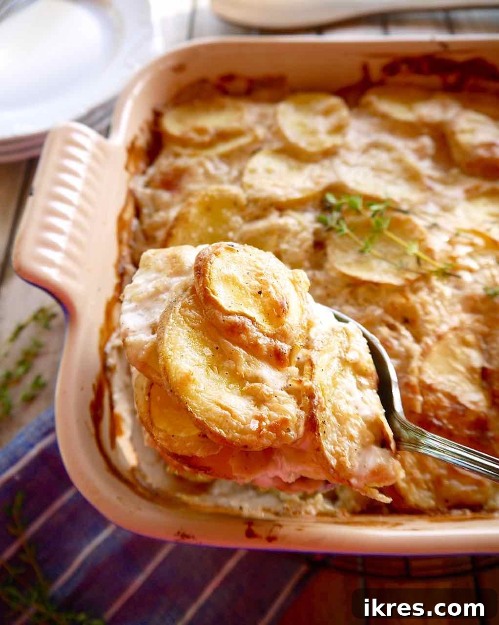 Creamy Dairy Free Scalloped Potatoes Paleo Whole30 Gluten Free 9 A serving spoon scooping out a generous portion of creamy dairy-free scalloped potatoes from the baking dish.