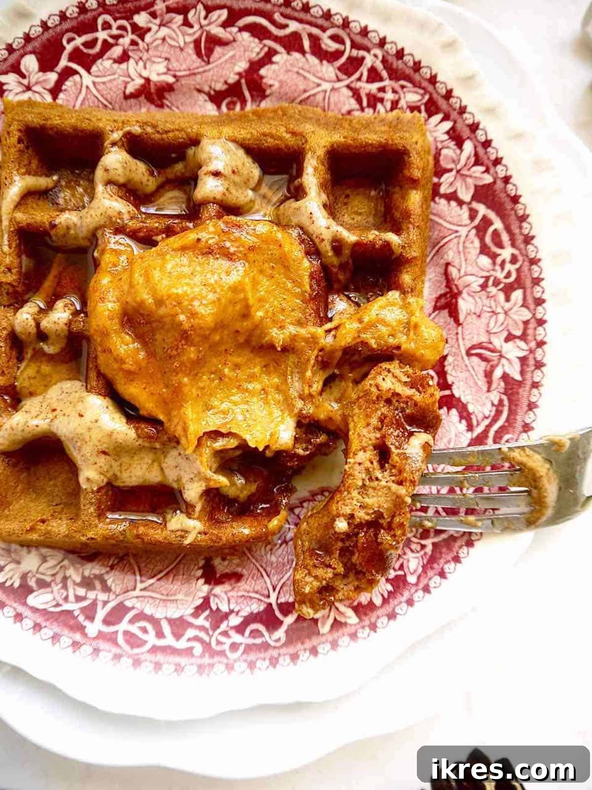 Paleo pumpkin waffles covered in pumpkin frosting.