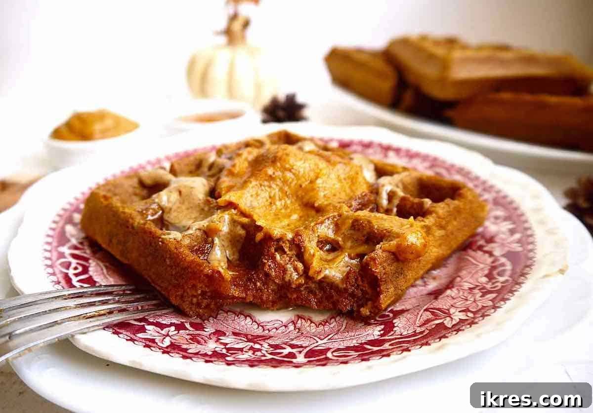 Paleo pumpkin waffles with a bite taken out of them.