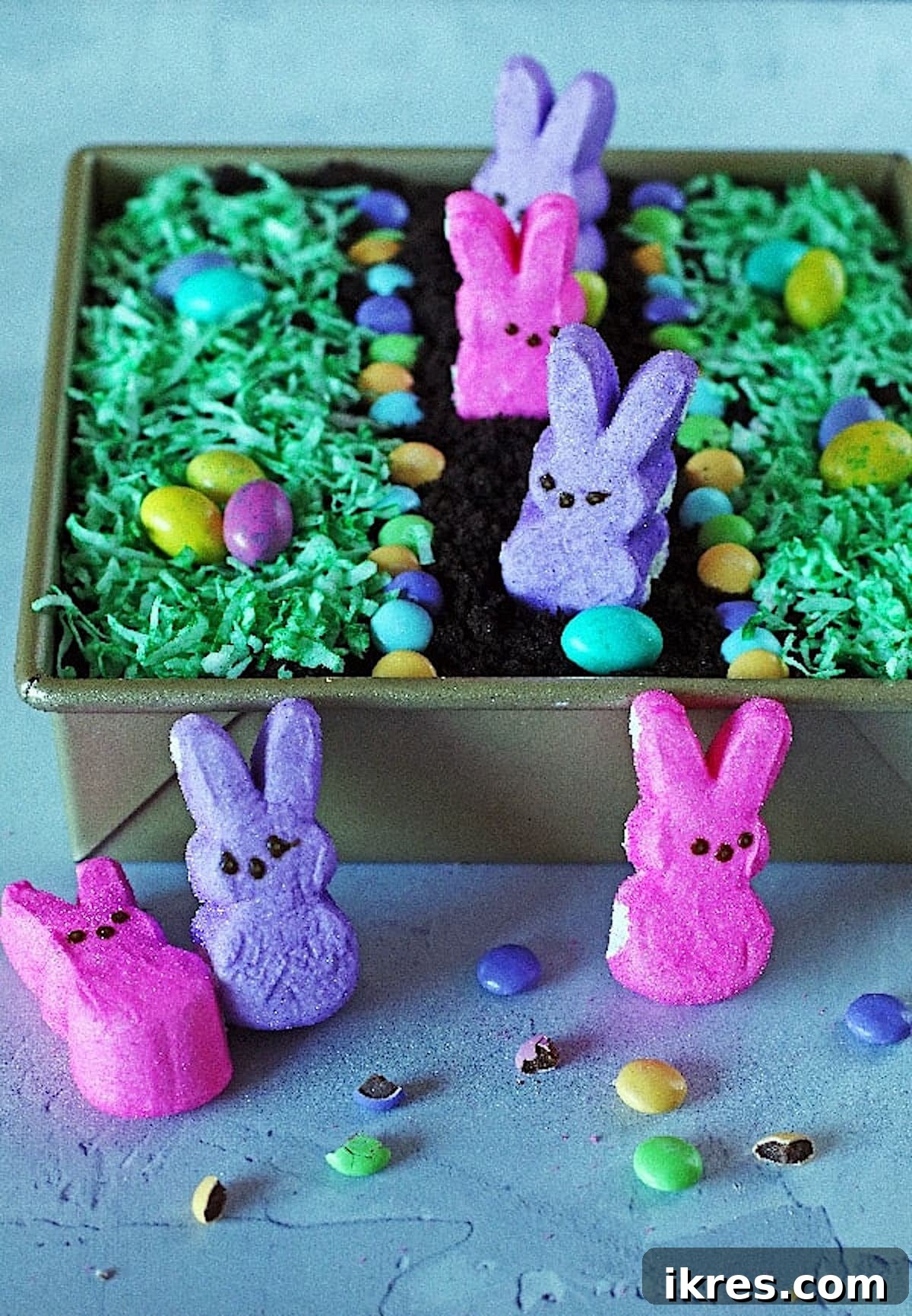 Festive Dirt Cake for Halloween and Easter 2 A charming Easter Dirt Cake decorated with fluffy bunny Peeps, colorful candy eggs, and bright green coconut grass, set against a festive backdrop. A perfect no-bake dessert for spring celebrations that kids and adults adore.