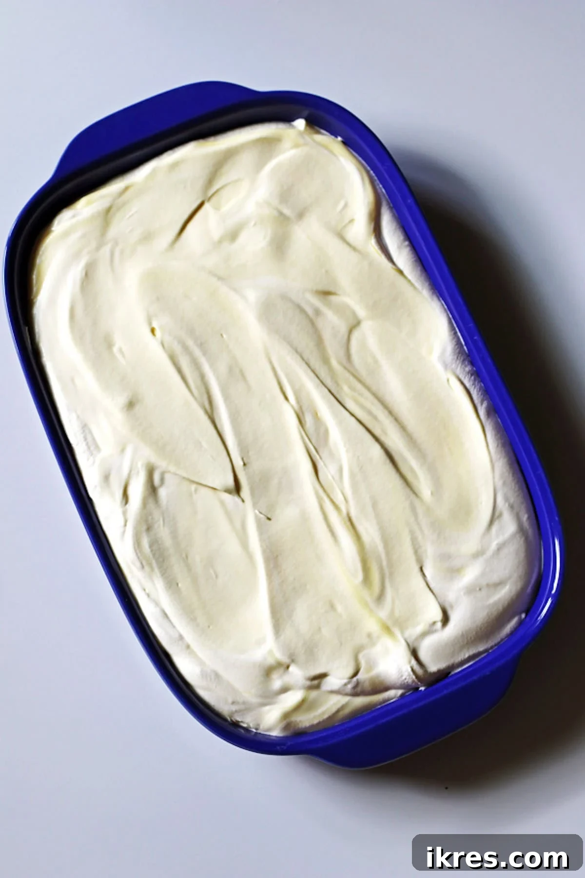 Festive Dirt Cake for Halloween and Easter 4 The creamy pudding mixture evenly spread out in a clear glass baking dish, forming the base layer for the Dirt Cake.