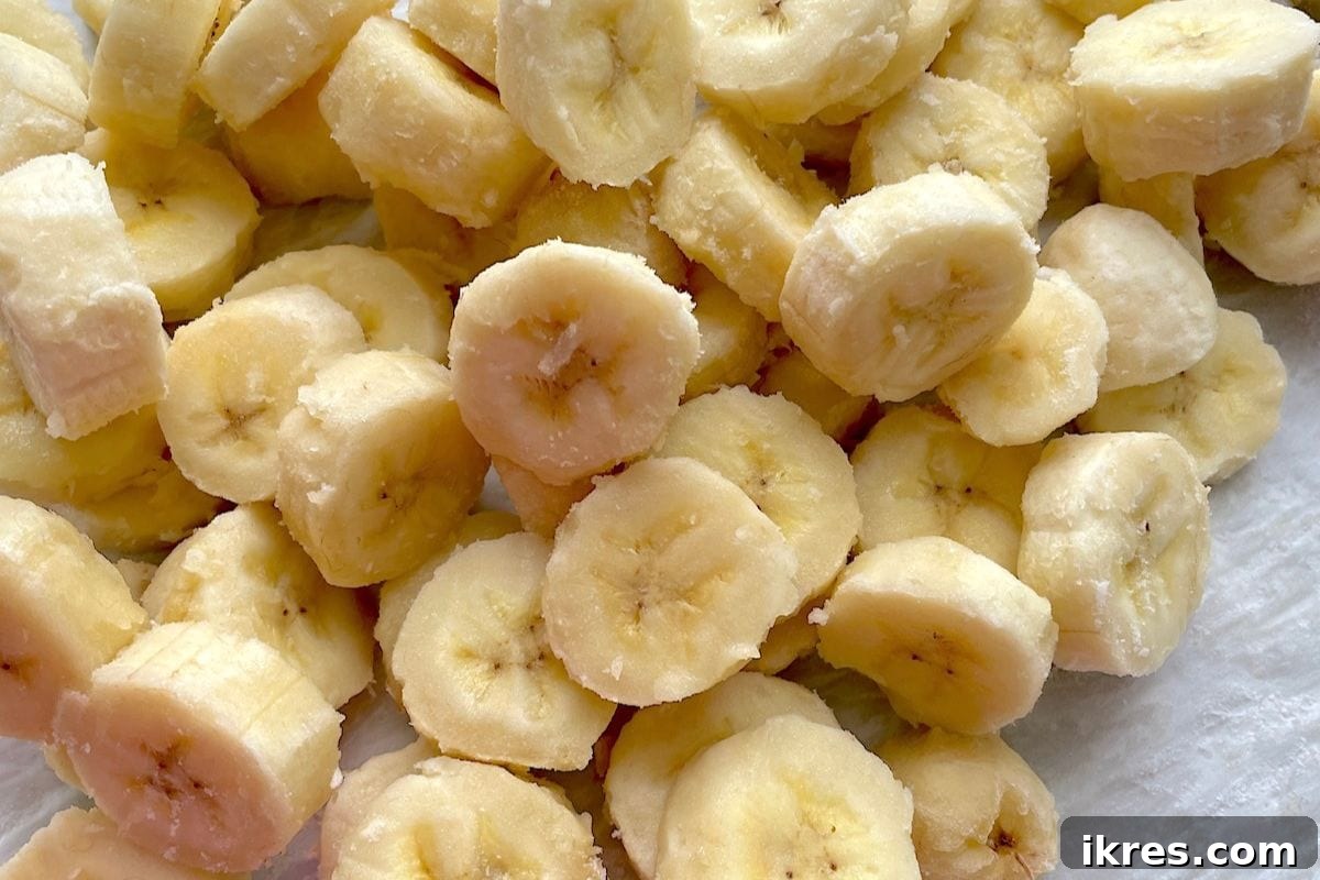 Sliced frozen bananas on a baking sheet.