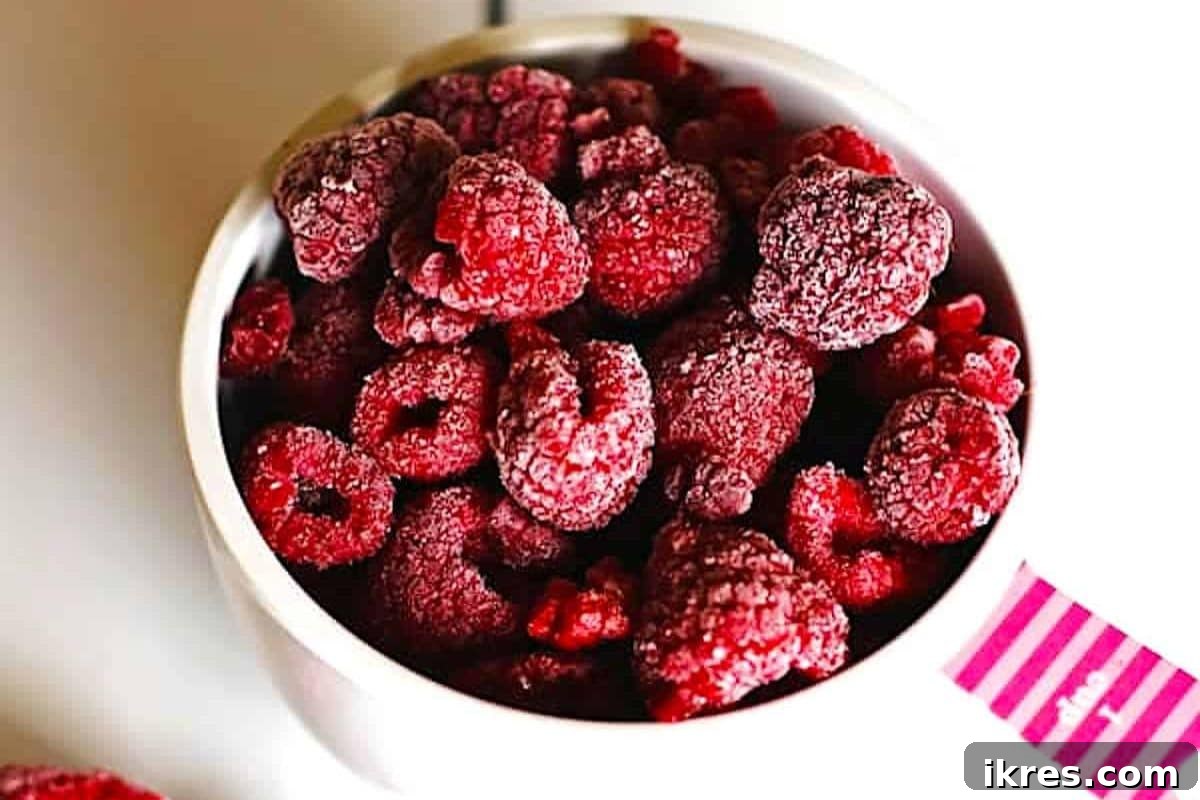 Fresh raspberries spread in a single layer on a baking sheet for freezing.