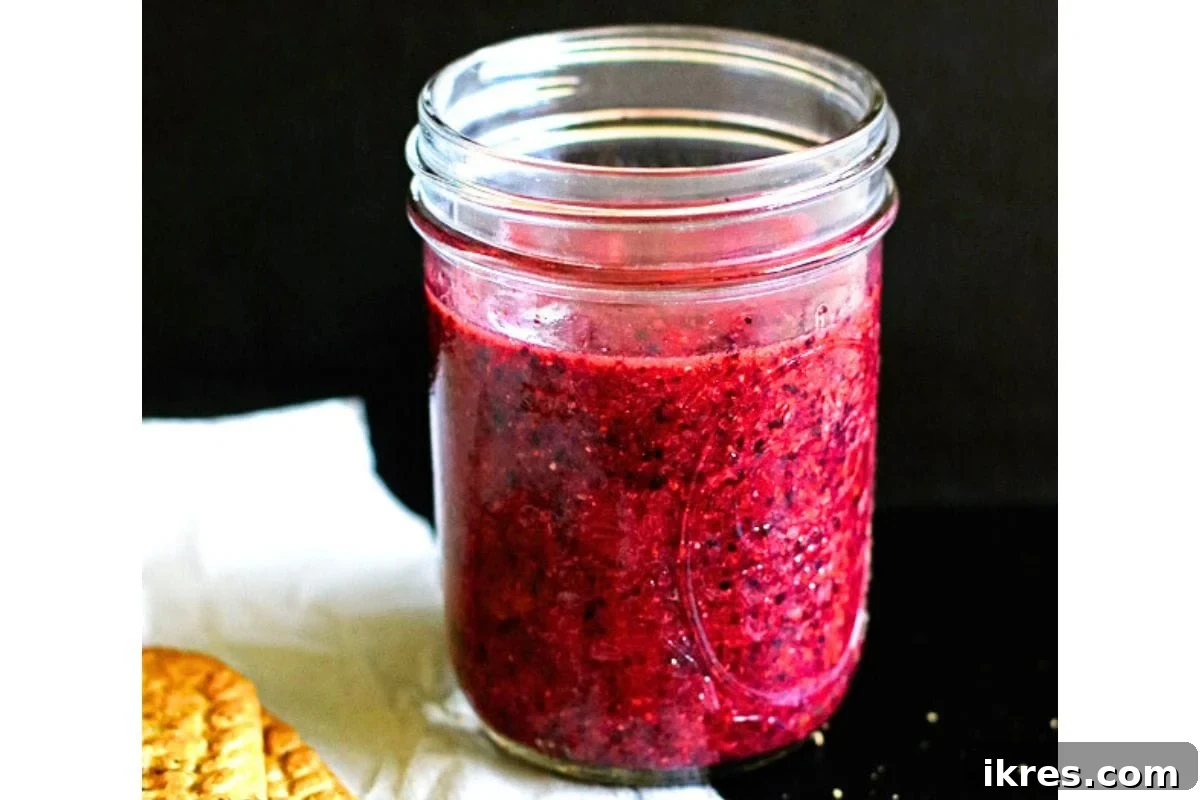 A tall glass of blueberry lemon smoothie with a straw.
