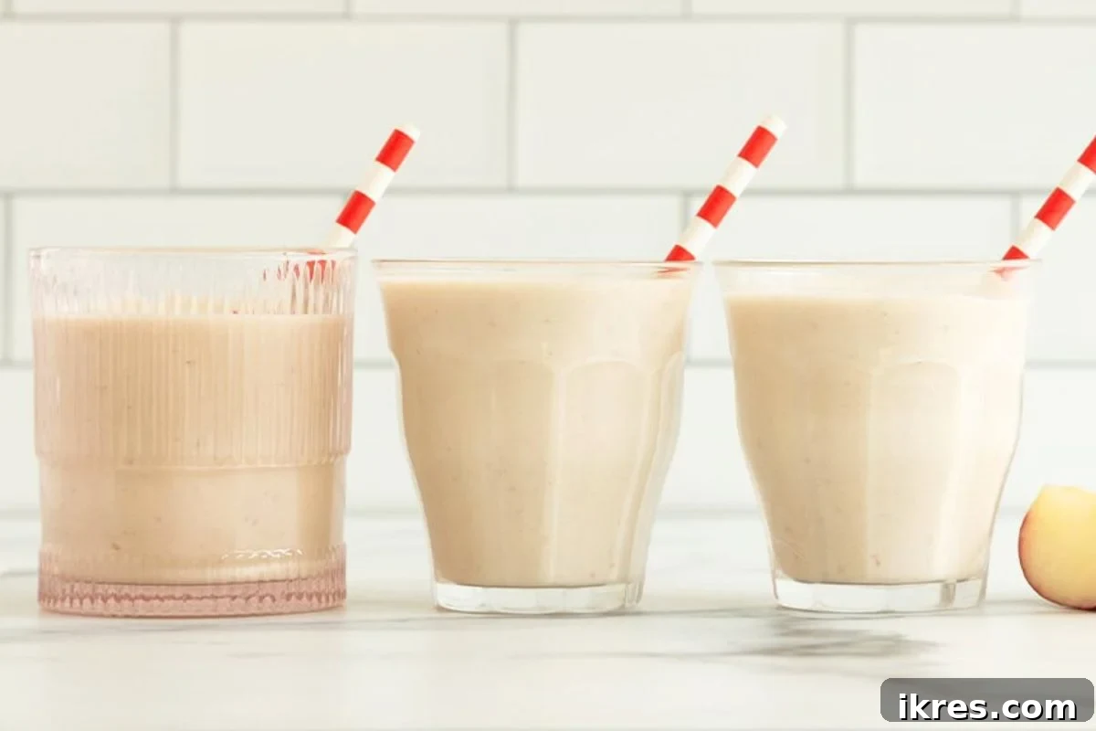 A green creamy apple smoothie in a glass with a straw.
