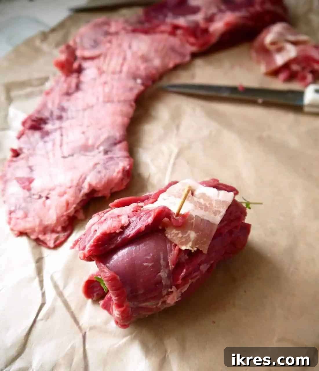 Beef Roulade Stuffed with Smoky Bacon, Sweet Onion, and Fresh Thyme 5 Beef steak rolled up with bacon and onion, secured with toothpicks, before cooking.