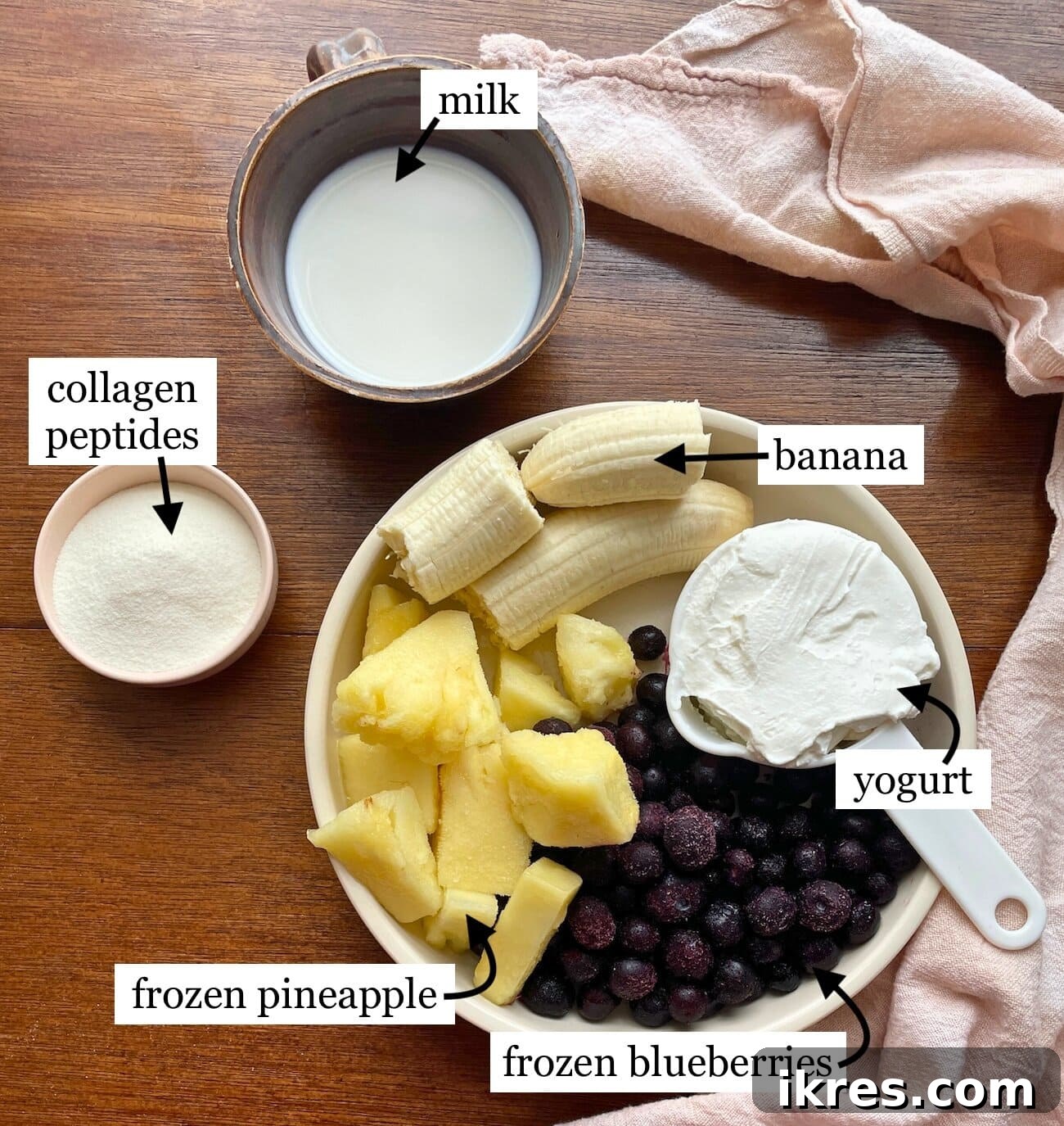 Vibrant Blueberry Pineapple Blast 3 All the fresh and frozen ingredients laid out for a homemade blueberry pineapple banana smoothie, including blueberries, pineapple chunks, a banana, Greek yogurt, and milk, ready for blending.