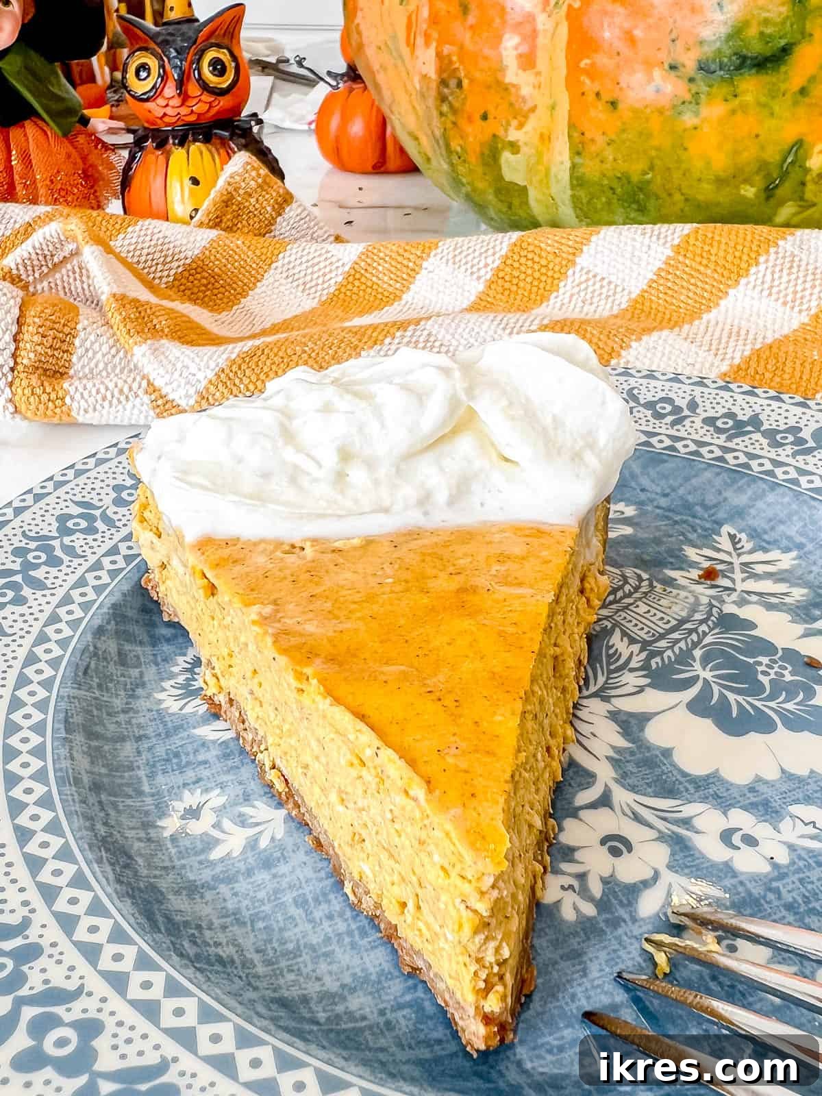 Gingersnap Crusted Pumpkin Cheesecake 12 A whole Pumpkin Cheesecake with Gingersnap Graham Cracker Crust, generously topped with whipped cream and ready to be served.