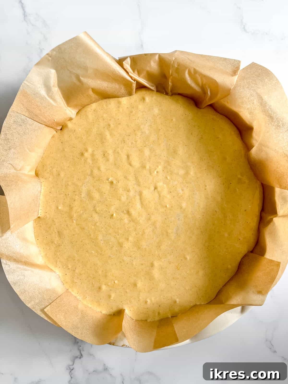 Gingersnap Crusted Pumpkin Cheesecake 10 The smooth pumpkin cheesecake batter poured over the chilled crust in the pie pan, ready for baking.