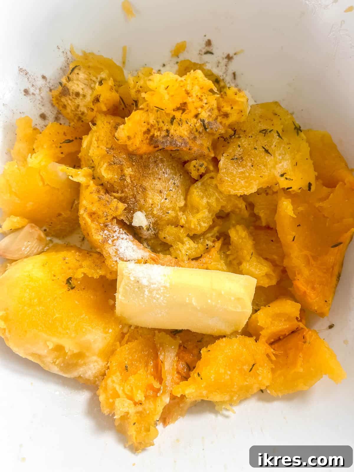 Golden Butternut Cloud 6 Scooped out roasted butternut squash flesh, softened roasted garlic, cubed butter, heavy cream, salt, and pepper gathered in a large mixing bowl, ready for mashing.