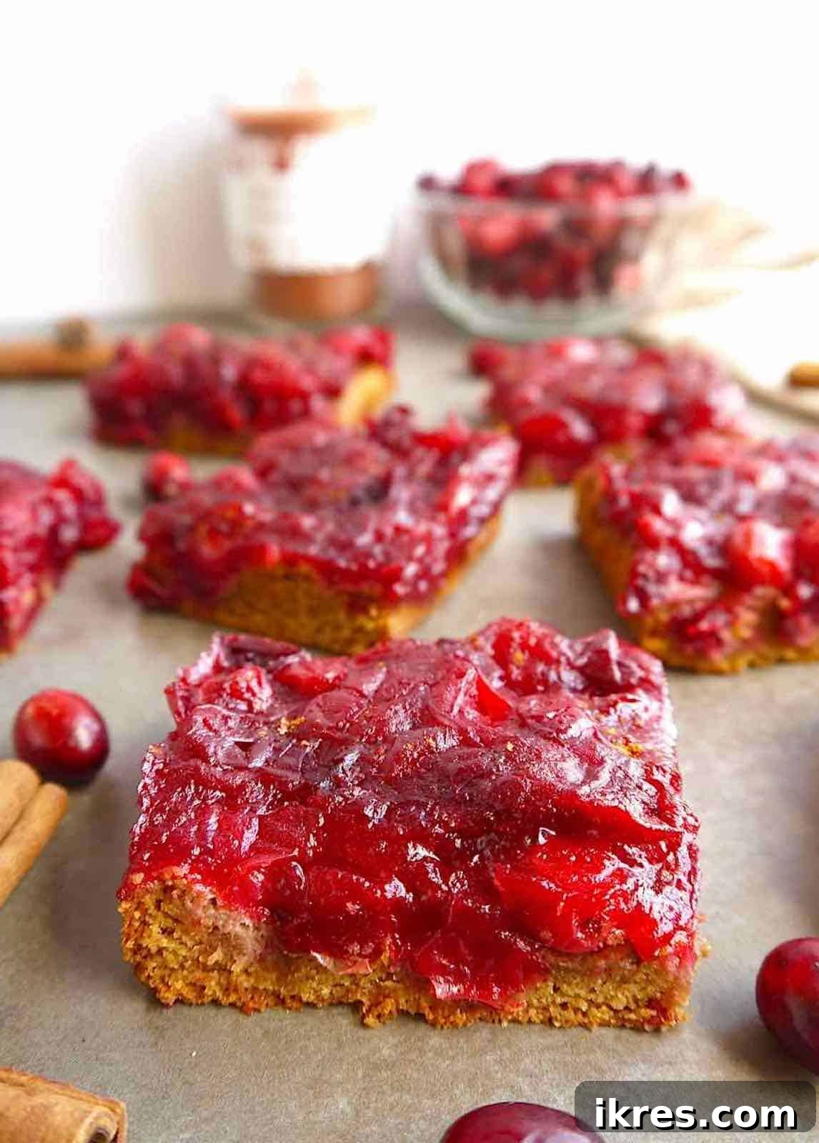A single gluten-free cranberry bar cut into a perfect square, showcasing its crumbly base and glossy top.