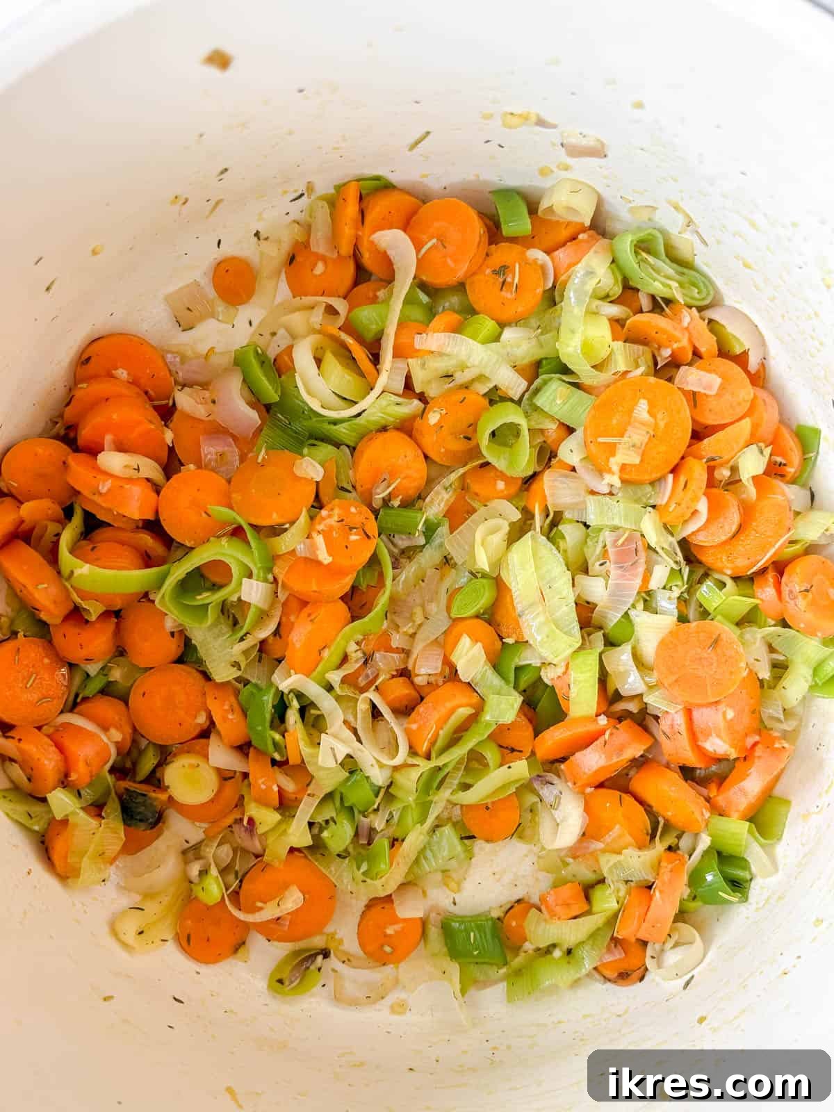 Hearty Homemade Tomato Vegetable Soup Recipe 4 Leeks, garlic, onion and carrot sauteéing in a large soup pot.