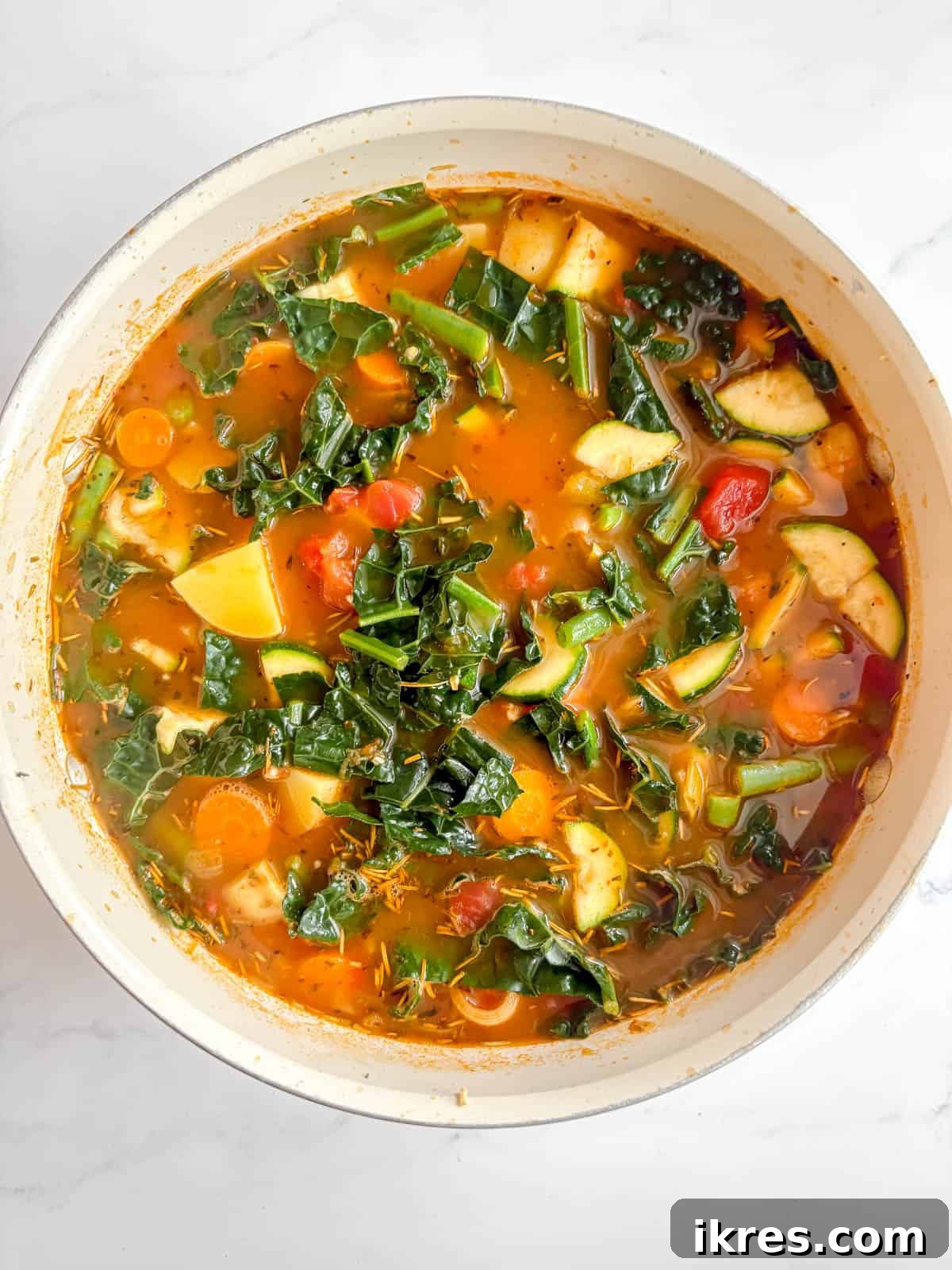 Hearty Homemade Tomato Vegetable Soup Recipe 6 Zucchini, kale, and green beans added to the simmering vegetable soup.