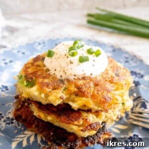 Gluten free potato pancakes on a plate with greek yogurt on top.