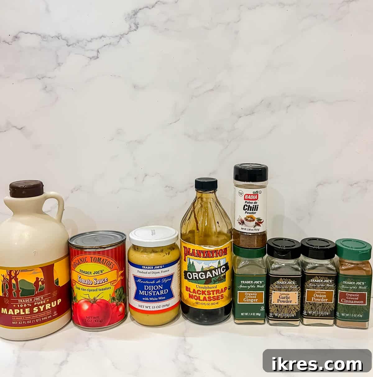 A collection of ingredients, including strained tomatoes, blackstrap molasses, and various spices, laid out for the homemade meatloaf sauce.