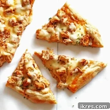 Slices of buffalo chicken pizza topped with chives on a white table.