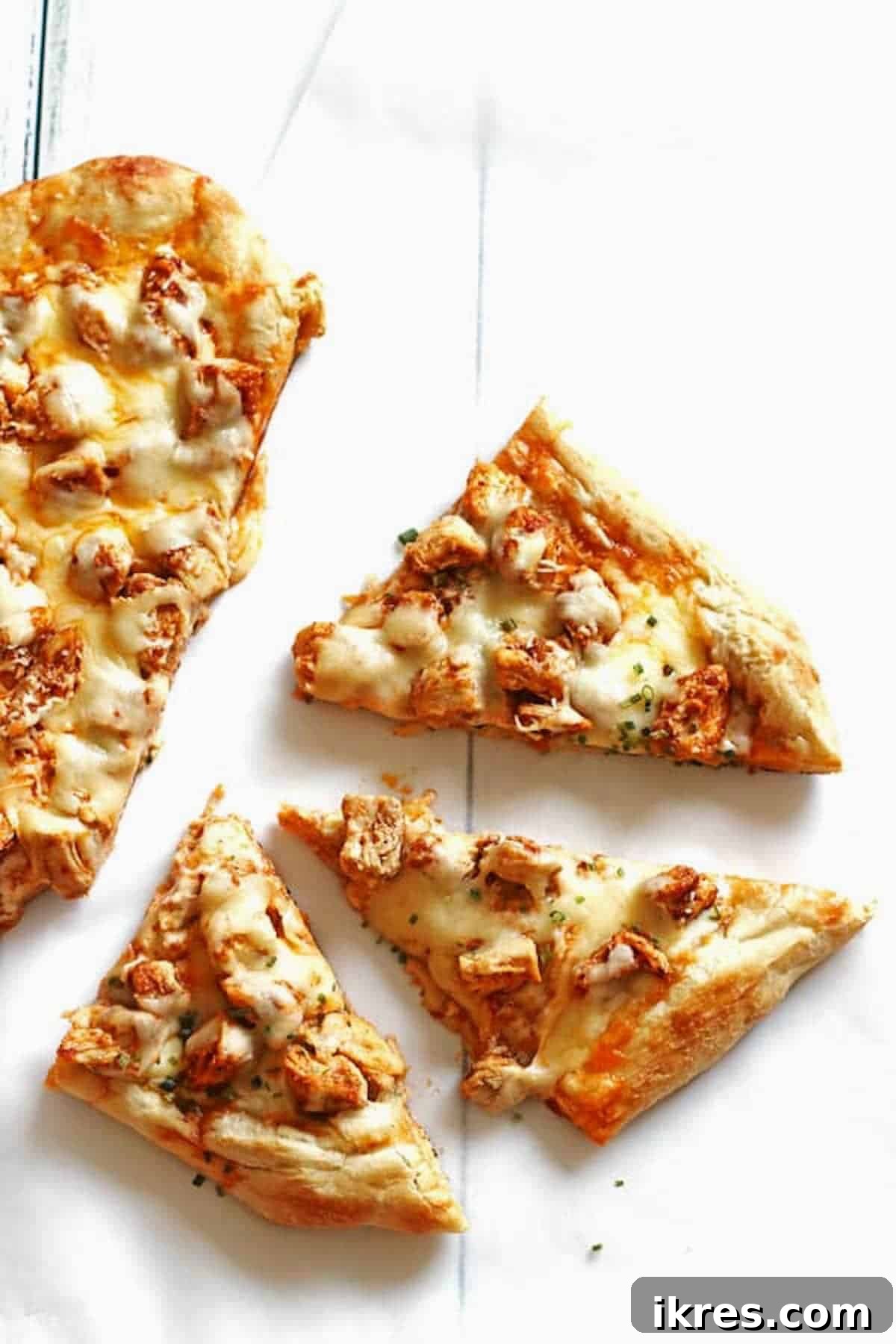 Ultimate Homemade Buffalo Chicken Pizza 5 Pizza with chicken and cheese sliced on a white table