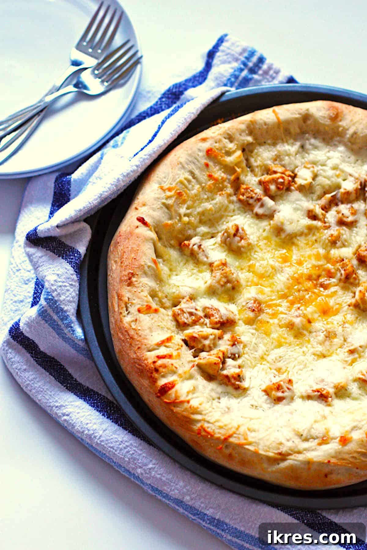 Ultimate Homemade Buffalo Chicken Pizza 6 A homemade buffalo chicken wing pizza in a round pan with thick crust.