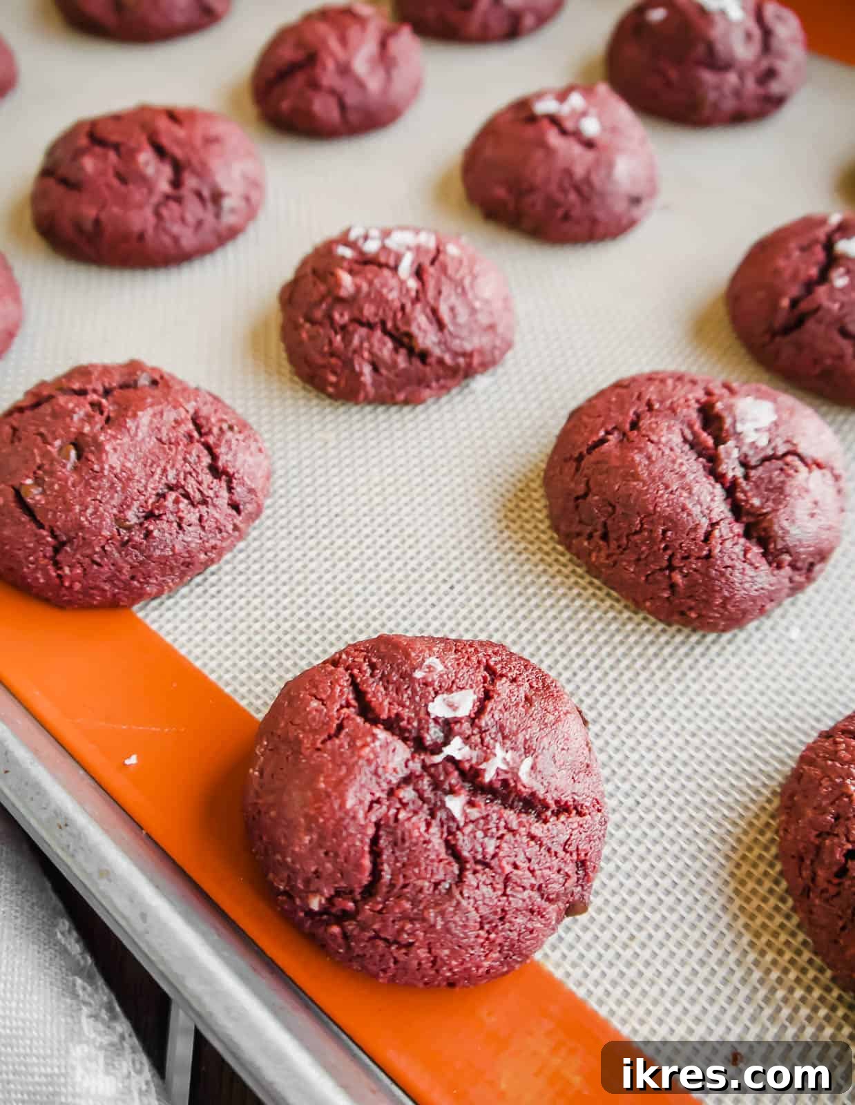 Irresistible Gluten-Free Red Velvet Delights 6 A stunning close-up of freshly baked gluten-free red velvet cookies cooling, with their perfect cracks and deep red color.