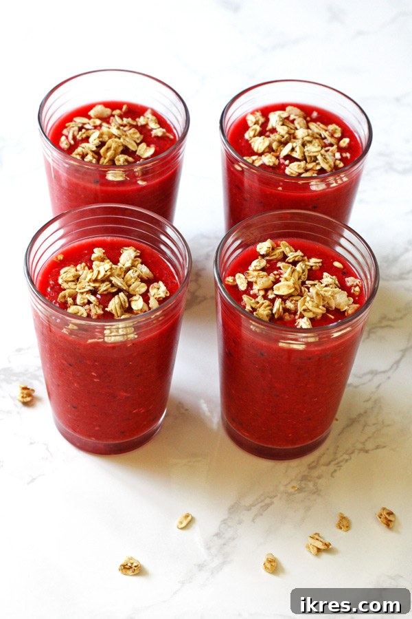 Morning Berry Granola Fuel 6 A beautifully composed mixed fruit and granola smoothie ready to be enjoyed, showcasing its wholesome, nutritious ingredients and vibrant colors.