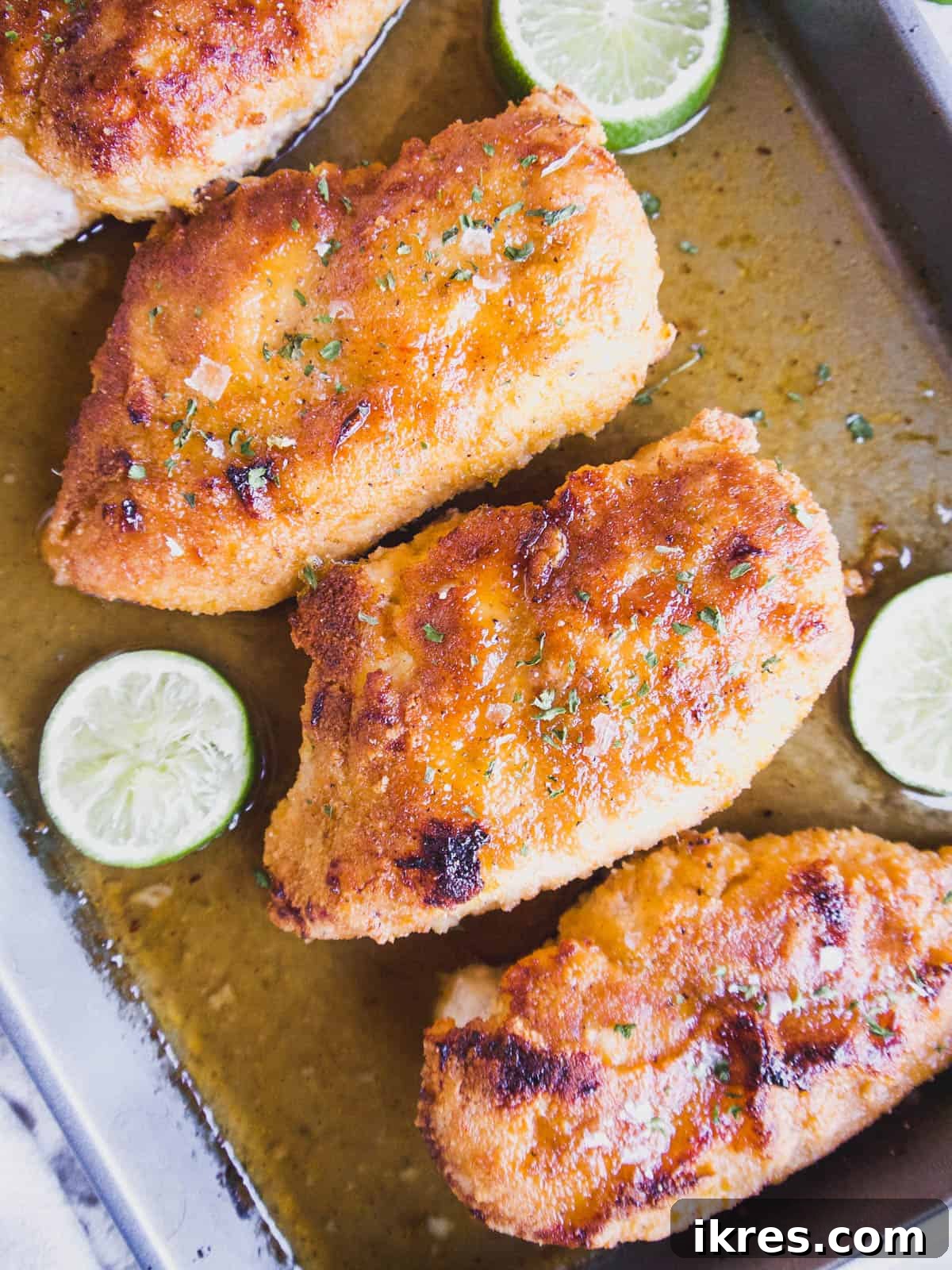 Baked almond flour maple lime chicken, golden brown and glistening with sauce, just pulled from the oven and ready to be served.