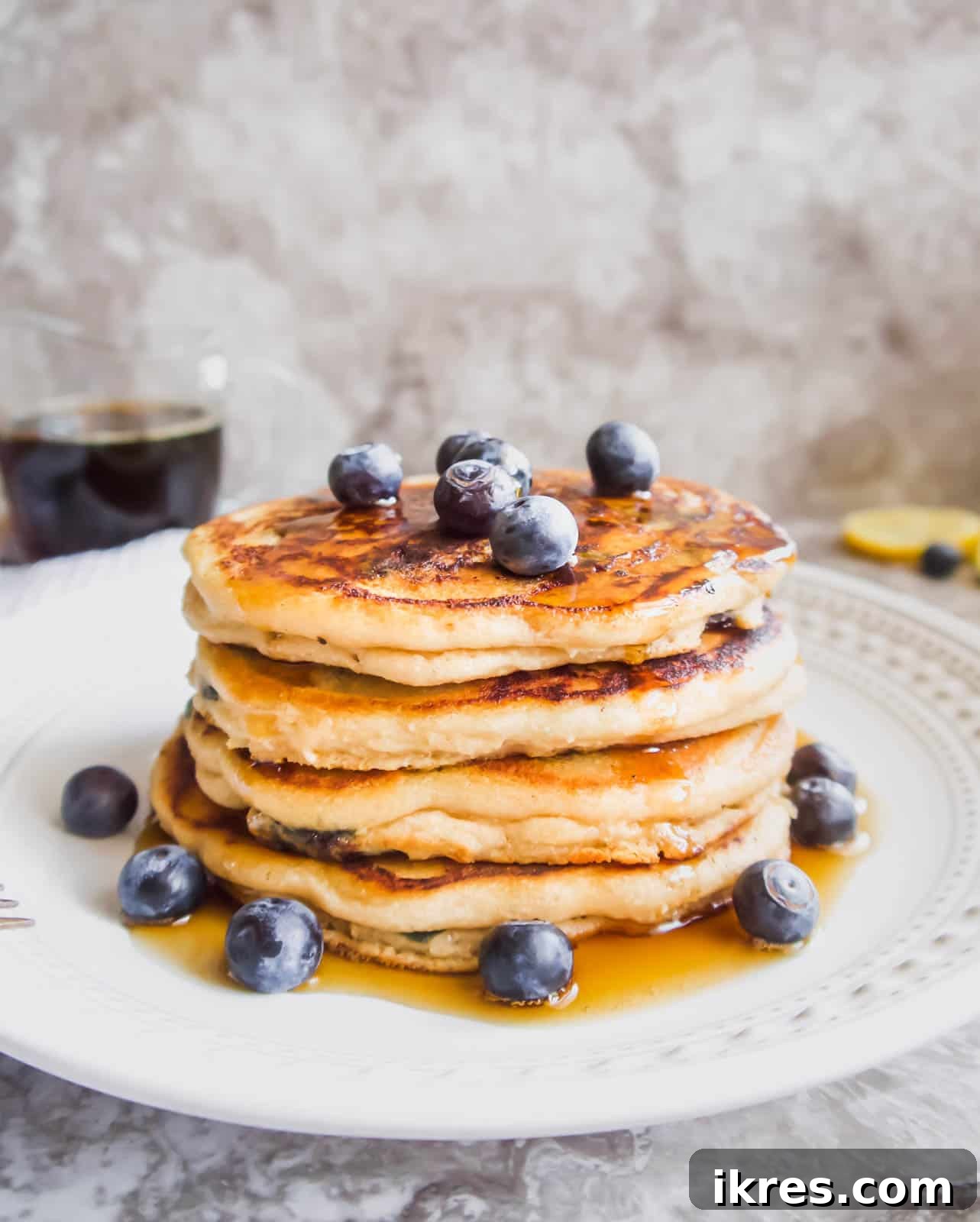 Fluffy Paleo Blueberry Pancakes 12 A beautifully presented stack of fluffy almond flour blueberry pancakes on a white plate, ready to be enjoyed.