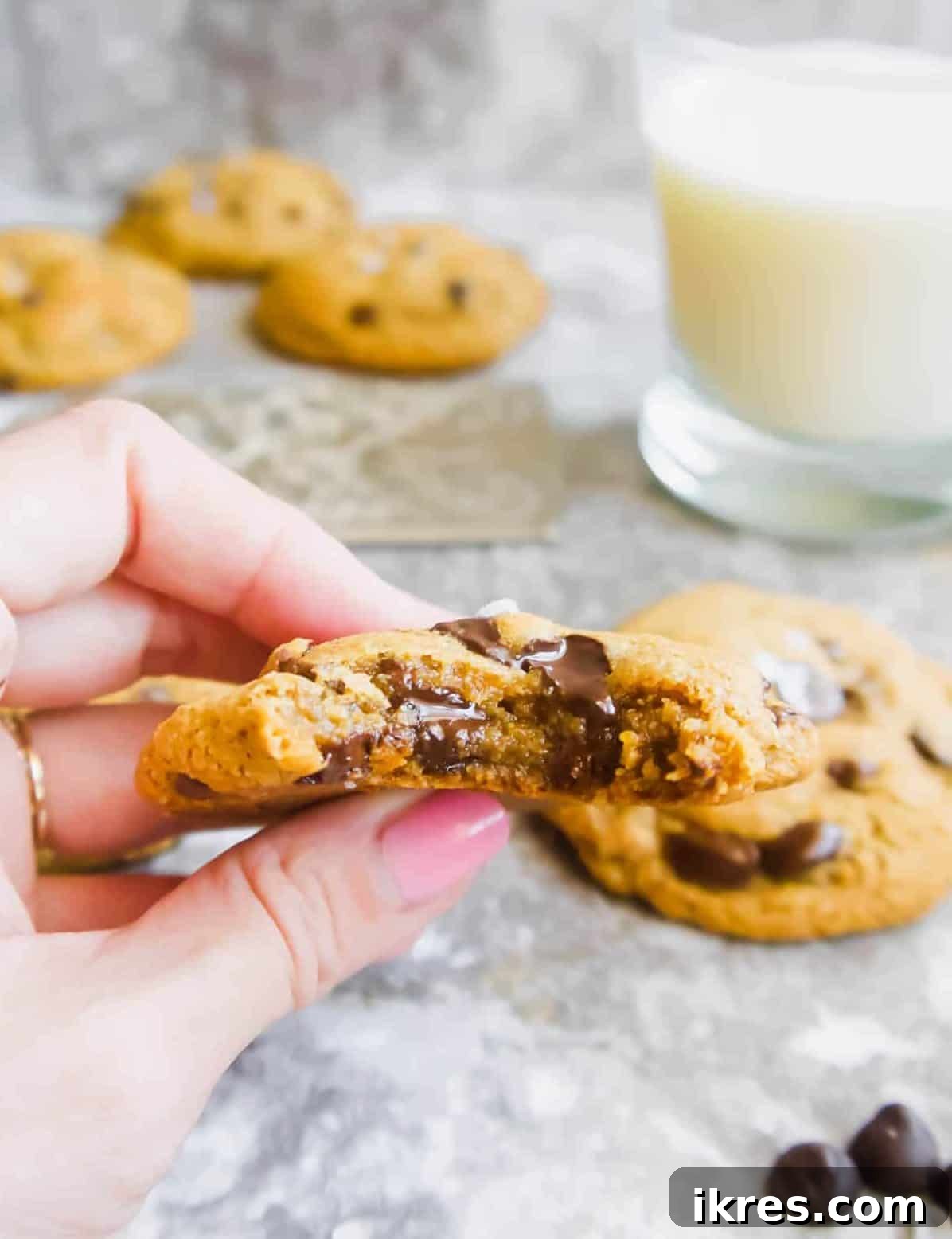 A perfectly baked Paleo chocolate chip cookie with a bite taken out, revealing its soft, gooey interior and melted chocolate chips.