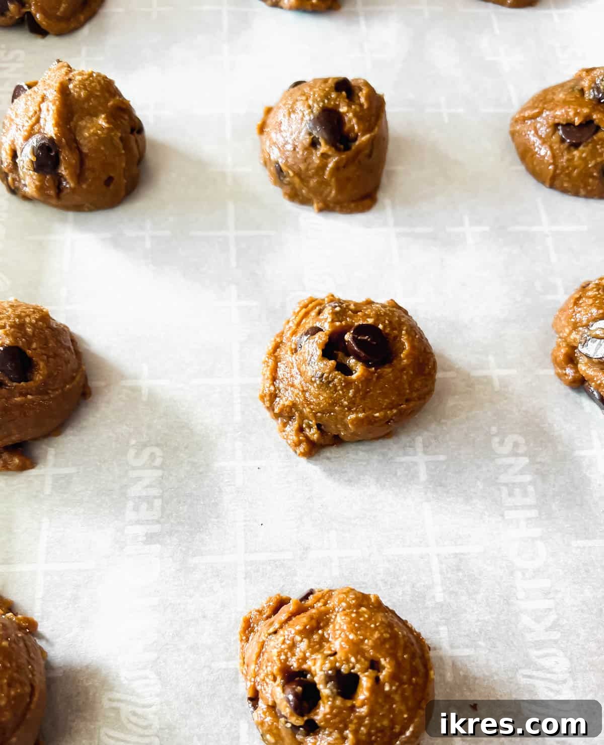 Grain and Dairy Free Paleo Chocolate Chip Cookies 8 Balls of Paleo chocolate chip cookie dough arranged on a baking sheet before baking.