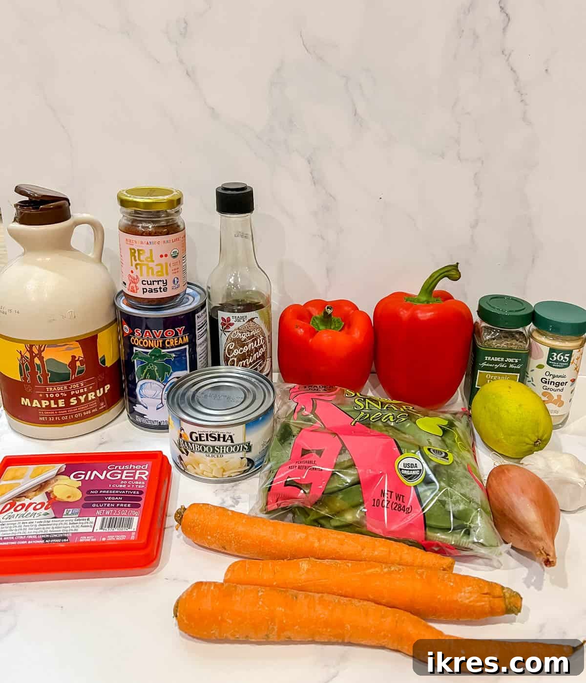 Plant-Based Paleo Thai Red Curry 3 A vibrant selection of fresh, colorful ingredients including carrots, bell peppers, ginger, and garlic, laid out for making vegan Thai red curry.